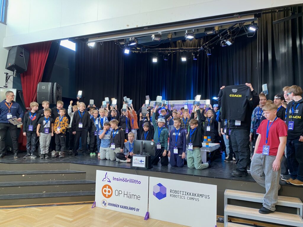 Suuri lapsiryhmä esiintymislavalla.